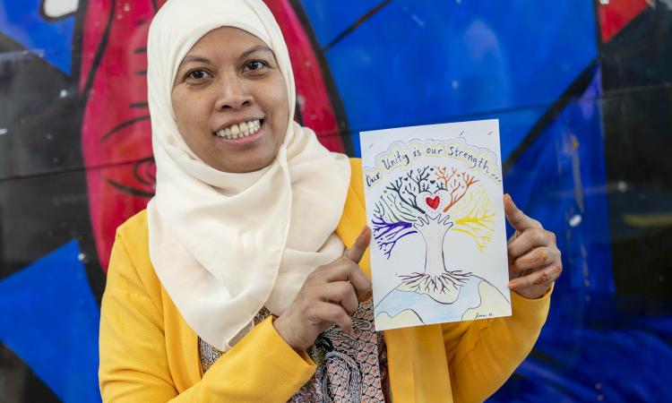 A woman holds a handmade postcard